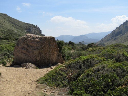 Aussicht nach hinten auf dem Weg nach Cala Bóquer mit einen großen Stein